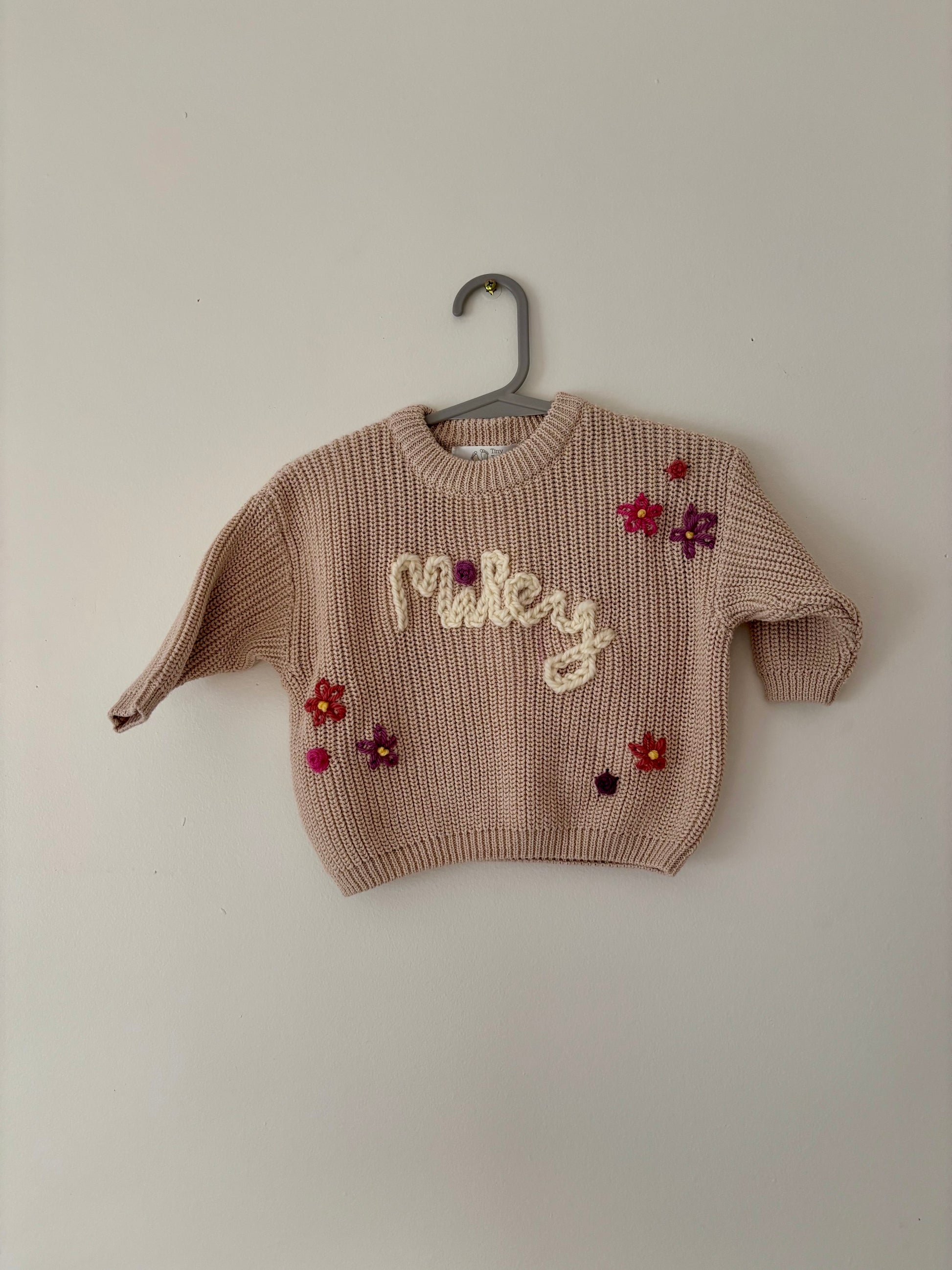 Children's sweater with floral designs and 'personalised name' text 